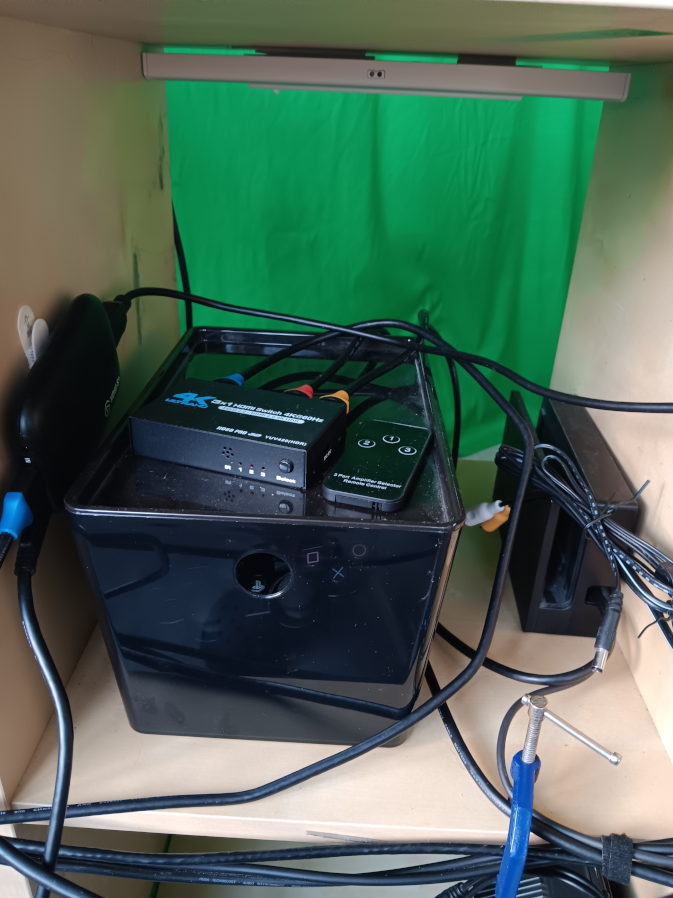 a collection of HDMI cables routing 2 separate inputs into the capture card. There's a Switch dock, a random rca jack, and a box with a ps3 controller in it