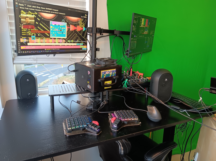 my desk with two screens and two sets of keyboards and other devices