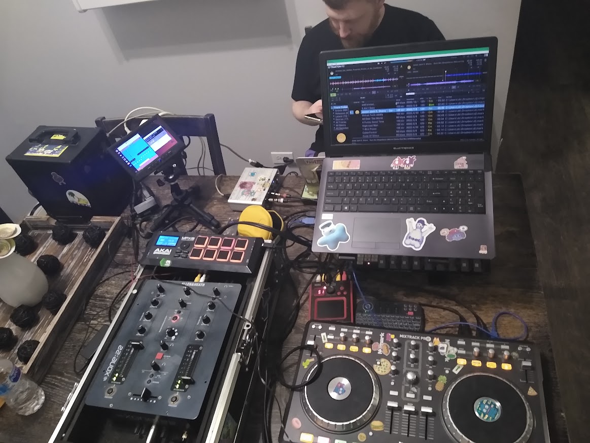 my mess of a setup as tony sits on the other side of the table on his phone